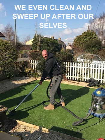 Honeys team member hoovering artificial grass after a clearance